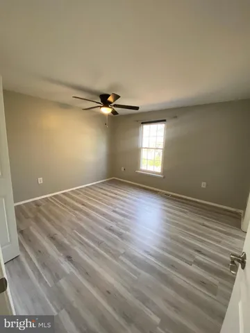 a view of empty room with window and wooden floor