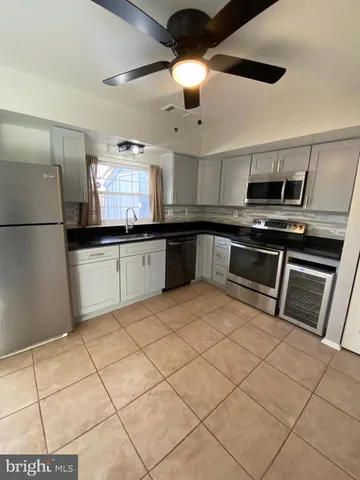 a kitchen with stainless steel appliances granite countertop a sink a stove a microwave a refrigerator a counter top space and cabinets