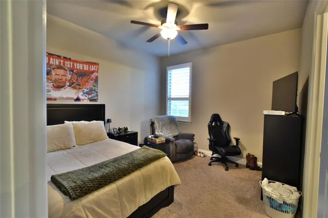 a bedroom with a bed a chair and a chandelier