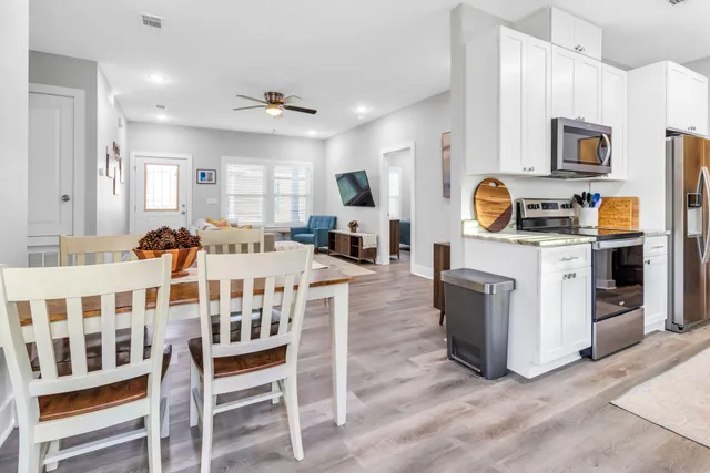 a living room with furniture a flat screen tv and kitchen view