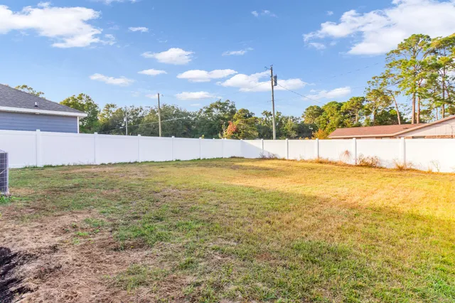 a view of a house with a big yard and a large tree