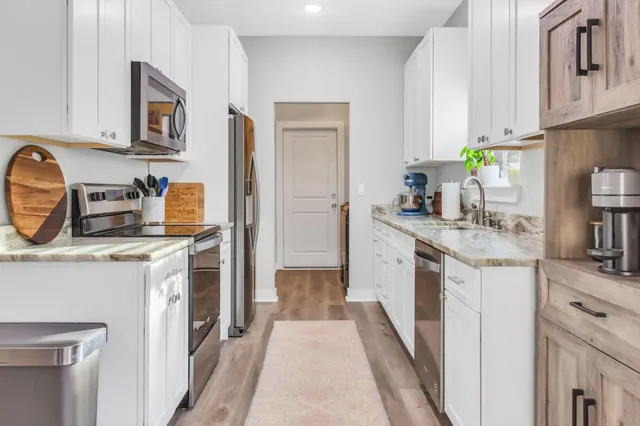 a kitchen with stainless steel appliances granite countertop a stove a sink and a refrigerator