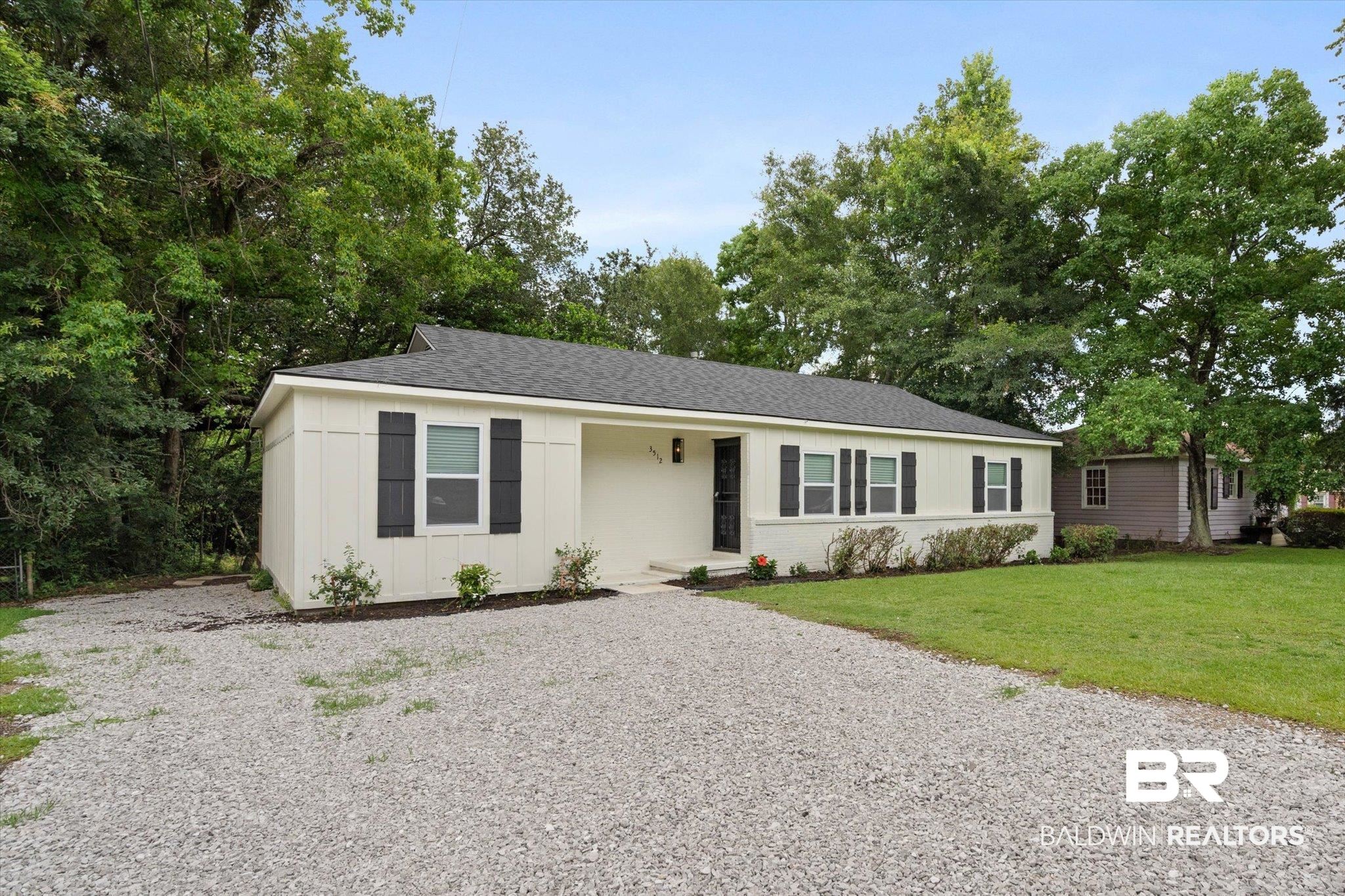 3512 Spring Hill Avenue Mobile, AL 36608 - Photo 20 of 20 Single story home featuring board and batten siding, a front yard, gravel driveway, and a shingled roof