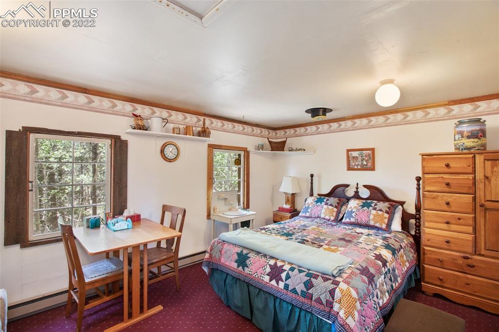7199 Cedar Mountain Road Divide, CO 80814 - Photo 26 of 34 a bedroom with a bed a table and chair