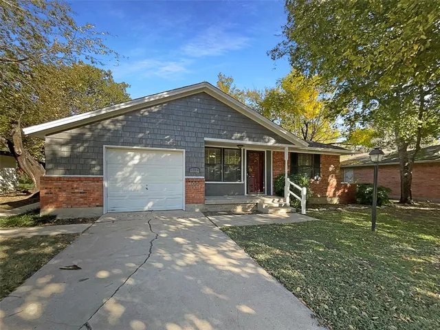a front view of a house with a yard and trees