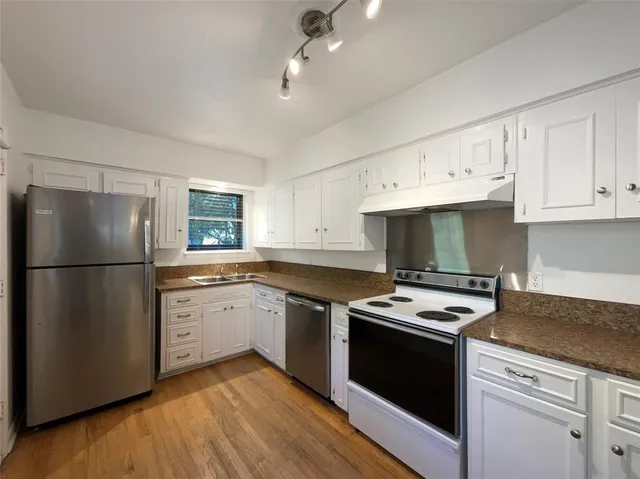 a kitchen with stainless steel appliances granite countertop a refrigerator sink and stove