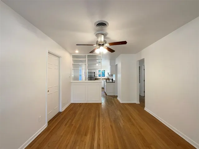 a very nice looking room with wooden floor and a ceiling fan