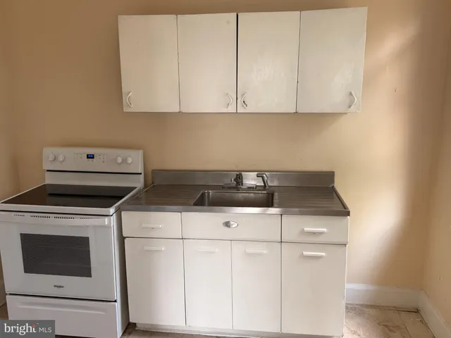 a stove top oven sitting inside of a kitchen
