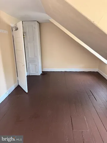 an empty room with wooden floor and entrance