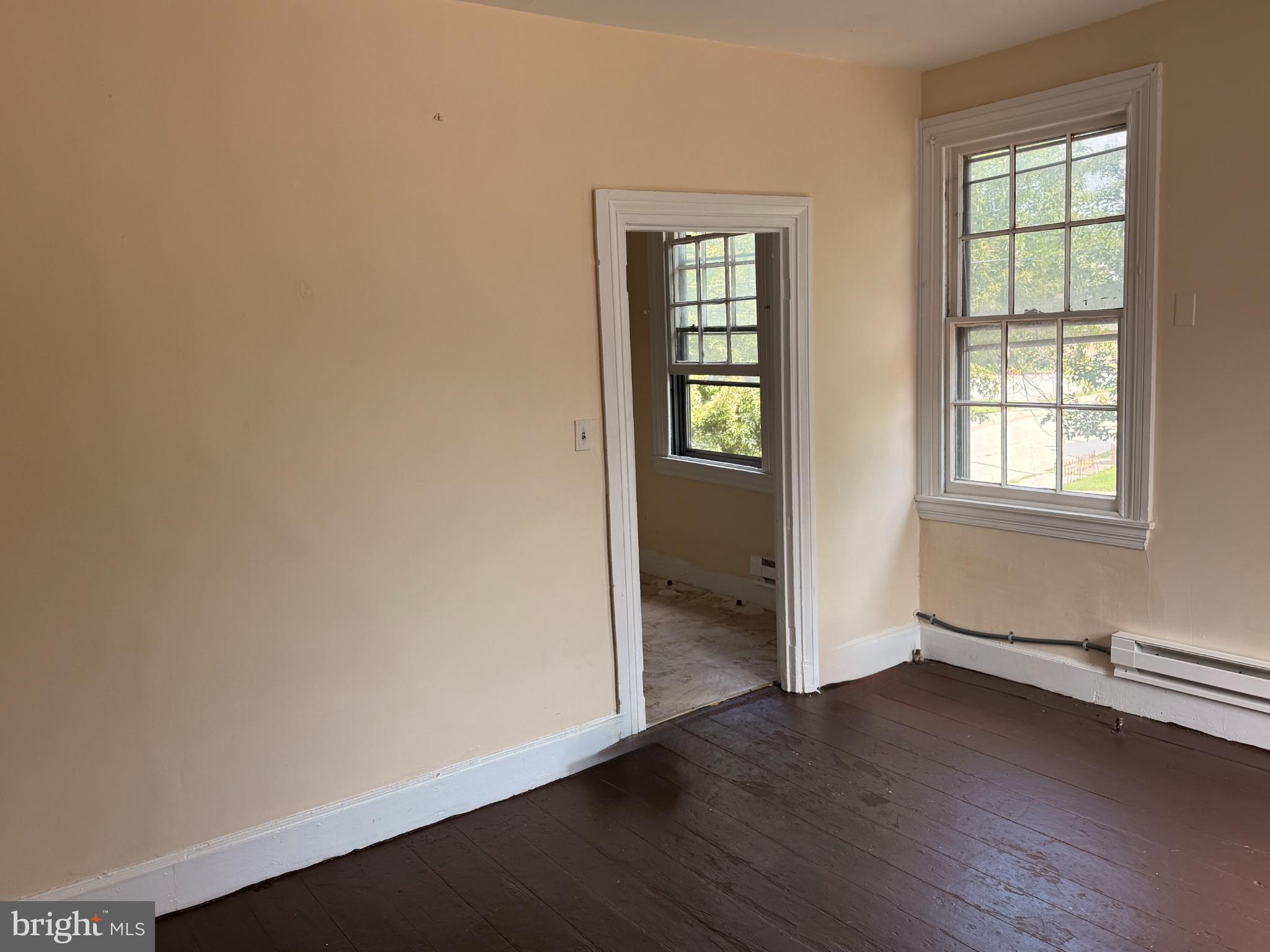 105 West Broadway, Unit C Salem, NJ 08079 - Photo 9 of 26 an empty room with wooden floor and windows