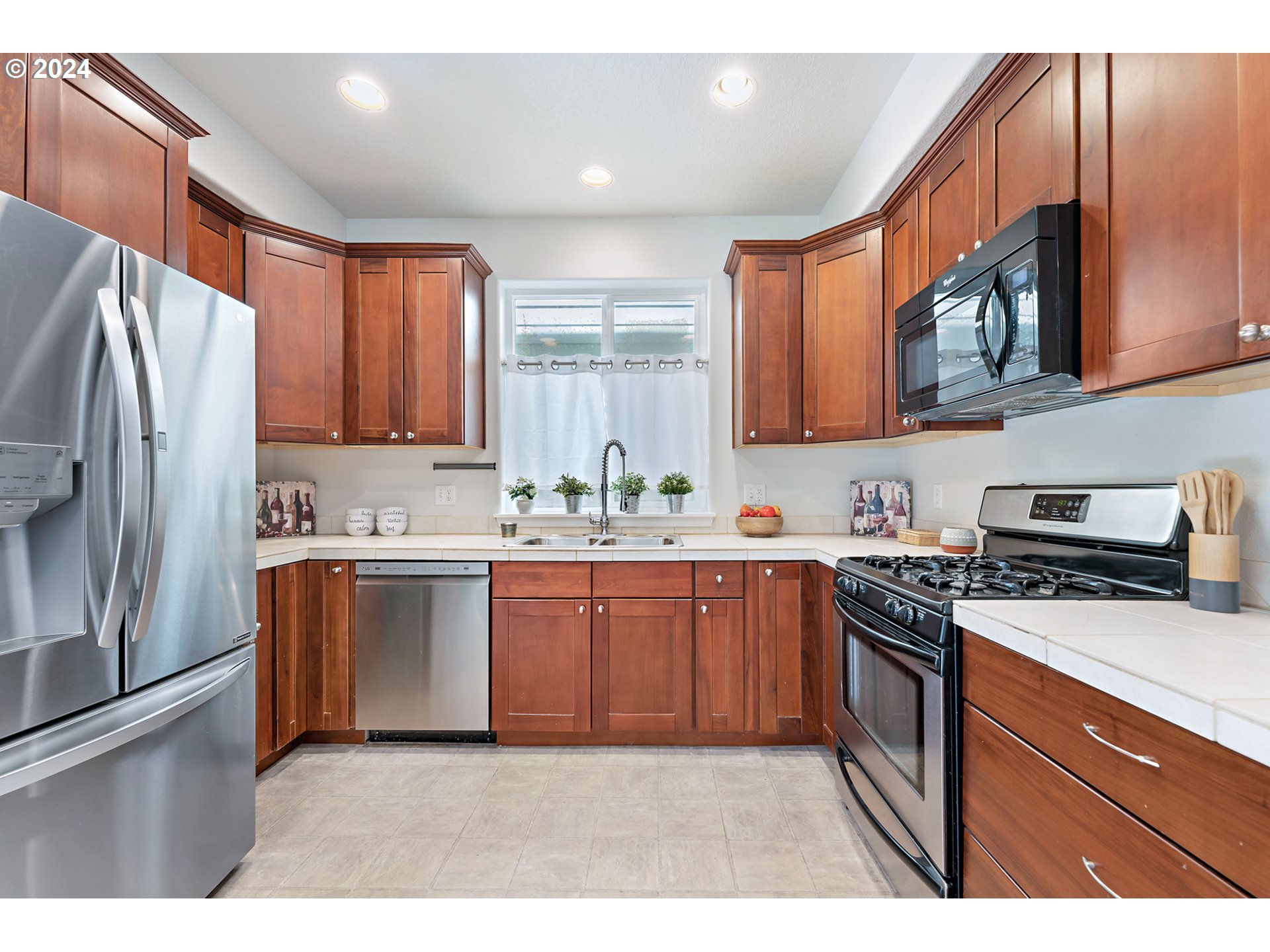 3149 Southwest 173rd Avenue Beaverton, OR 97003 - Photo 11 of 35 a kitchen with stainless steel appliances granite countertop a stove a sink dishwasher a refrigerator and cabinets with wooden floor