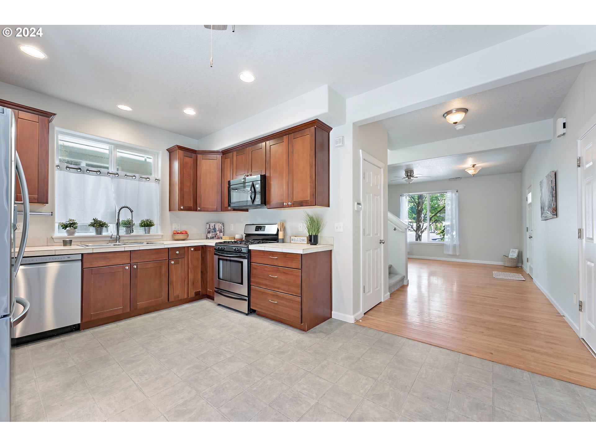 3149 Southwest 173rd Avenue Beaverton, OR 97003 - Photo 14 of 35 a room with stainless steel appliances kitchen island granite countertop a refrigerator a sink dishwasher and a stove with wooden floor