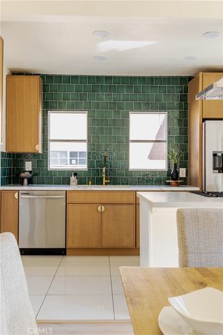a kitchen with stainless steel appliances kitchen island granite countertop a sink and a white cabinets