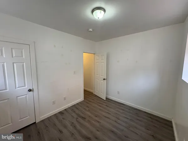 an empty room with wooden floor and entrance