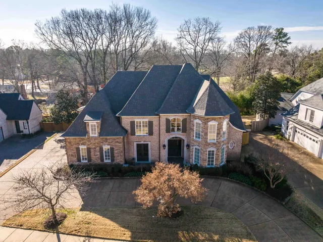 a view of a brick house with a yard next to a road
