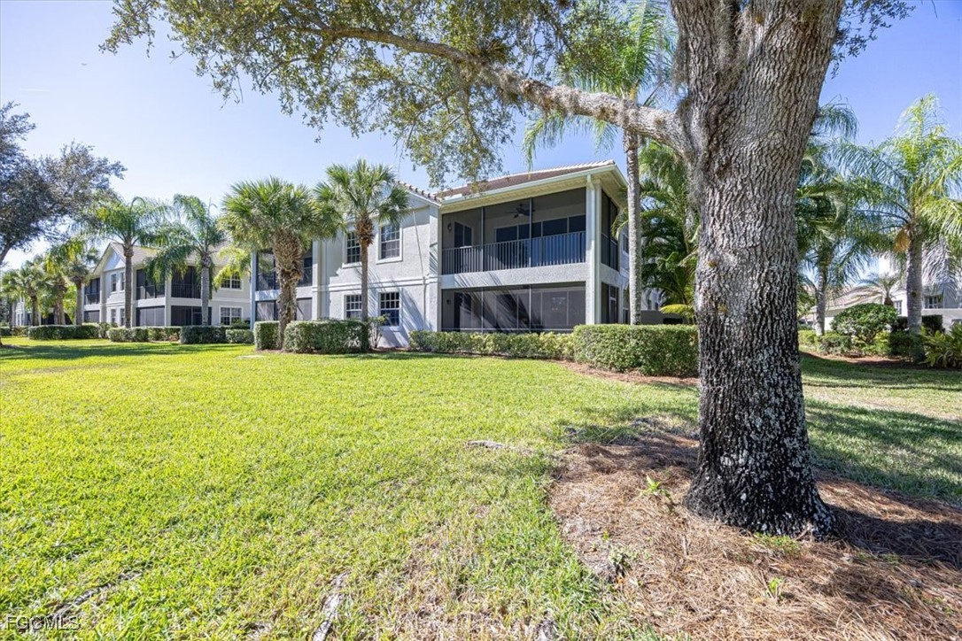 13091 Pebblebrook Ridge Court, Unit 101 Fort Myers, FL 33905 - Photo 12 of 39 a large tree in front of a house with a yard