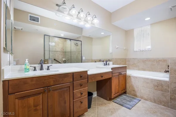 a bathroom with a sink double vanity granite tub and a mirror
