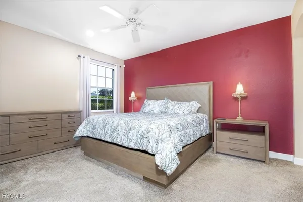 a bedroom with a bed and a chandelier fan