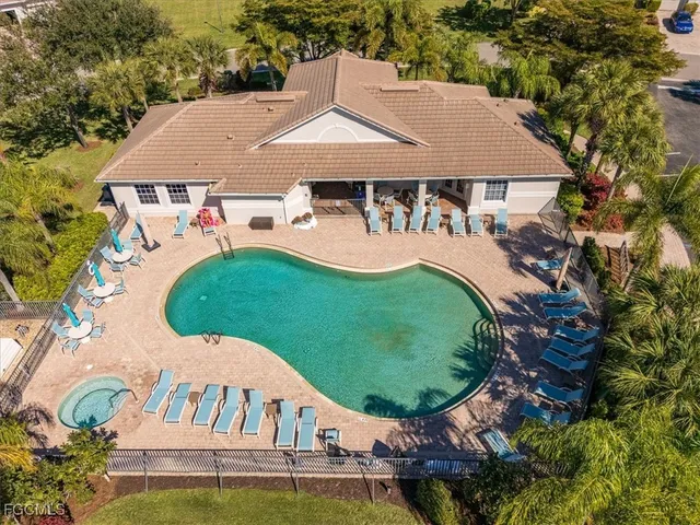 a view of swimming pool with a yard and palm trees