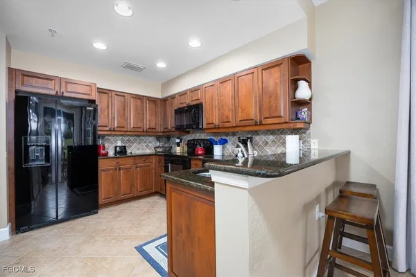 a kitchen with stainless steel appliances granite countertop a refrigerator a stove top oven a sink and dishwasher