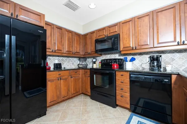 a kitchen with stainless steel appliances granite countertop a refrigerator and a stove top oven