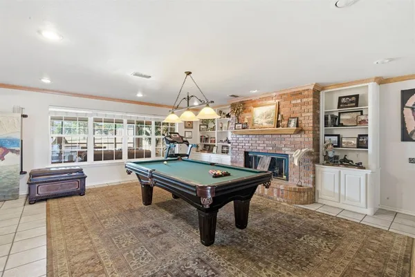 a room with pool table table and windows