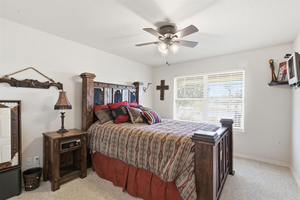 2691 North Fm Road 51 Springtown, TX 76082 - Photo 18 of 40 a bedroom with a bed and a chandelier