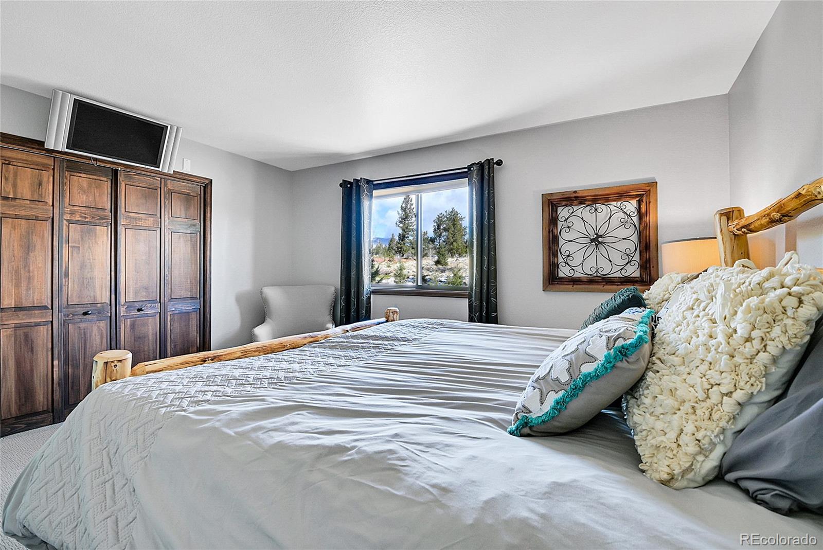 1567 Tapadero Road Bailey, CO 80421 - Photo 15 of 26 a bedroom with a large bed and a tv