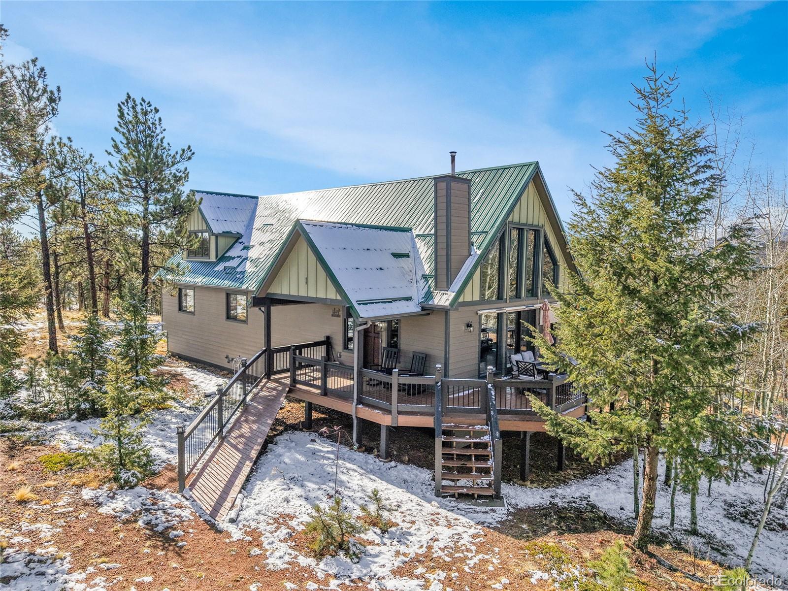 1567 Tapadero Road Bailey, CO 80421 - Photo 22 of 26 a view of a house with a wooden deck and trees
