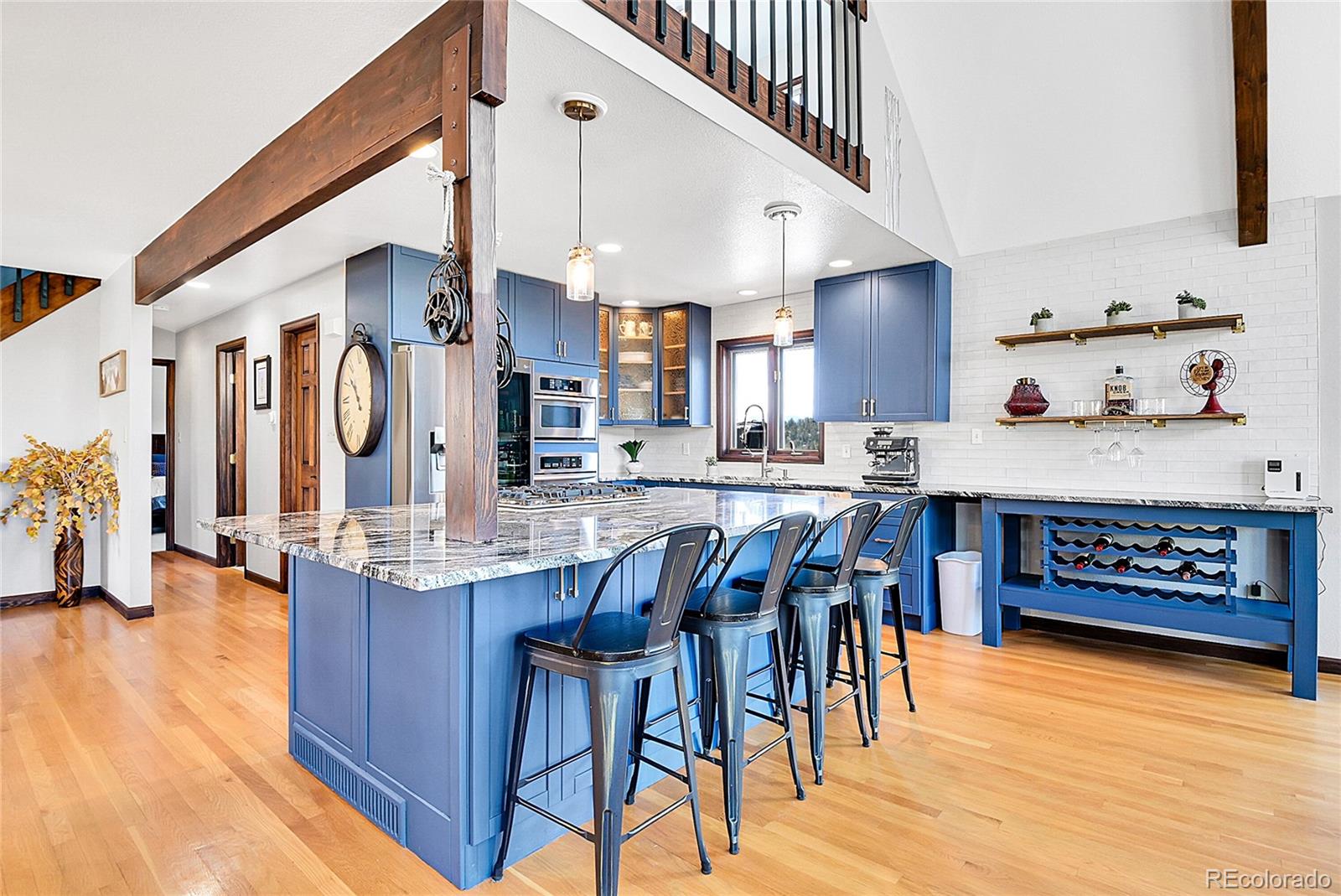 1567 Tapadero Road Bailey, CO 80421 - Photo 5 of 26 a kitchen with stainless steel appliances granite countertop a stove top oven a sink a dining table and chairs with wooden floor