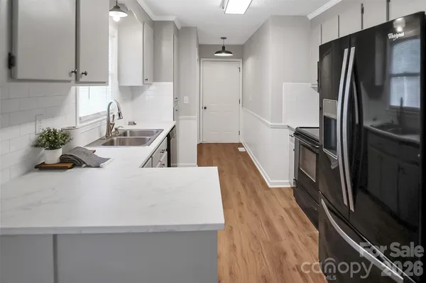 a kitchen with kitchen island a counter top space a refrigerator and a sink