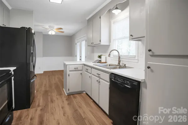 a kitchen with a sink cabinets stainless steel appliances and a window
