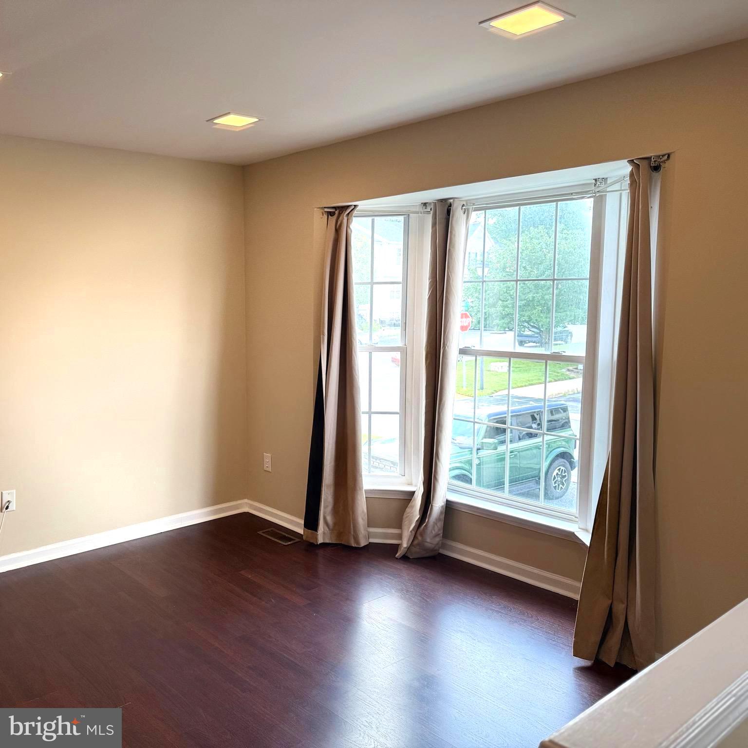19 Spring Drive Newark, DE 19702 - Photo 5 of 47 an empty room with wooden floor and windows