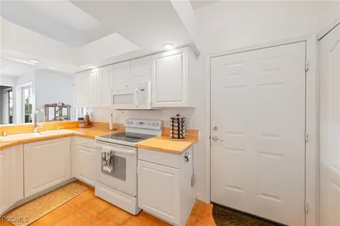 a kitchen with a sink cabinets stainless steel appliances and a window