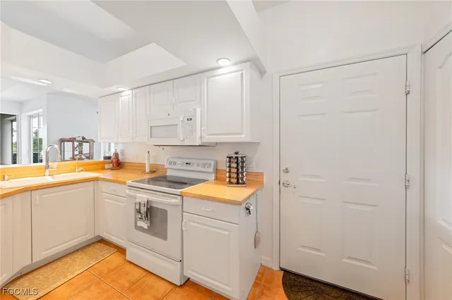 a kitchen with a sink cabinets stainless steel appliances and a window