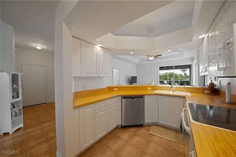 a large kitchen with a sink and dishwasher a stove top oven with wooden floor