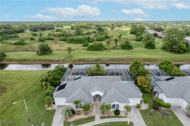 an aerial view of a house with a yard and lake view