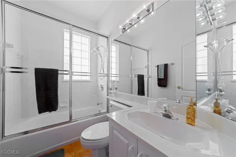 a bathroom with a sink a toilet a mirror and shower