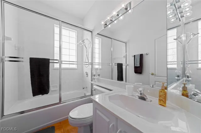 a bathroom with a sink a toilet a mirror and shower