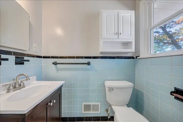 a bathroom with a toilet sink and mirror