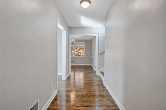 a view of a hallway with wooden floor