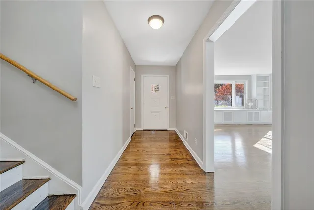 a view of a hallway with wooden floor and staircase