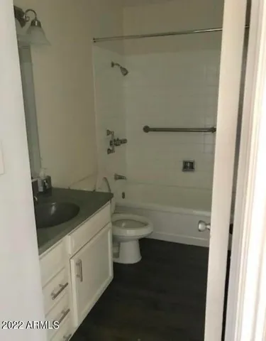 a bathroom with a granite countertop toilet a sink and a bathtub