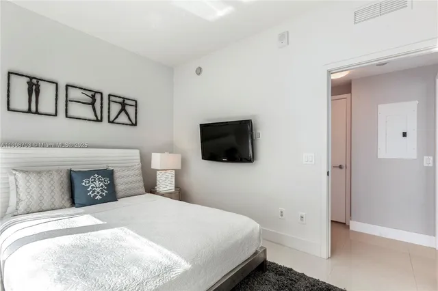 a bedroom with a bed and a television