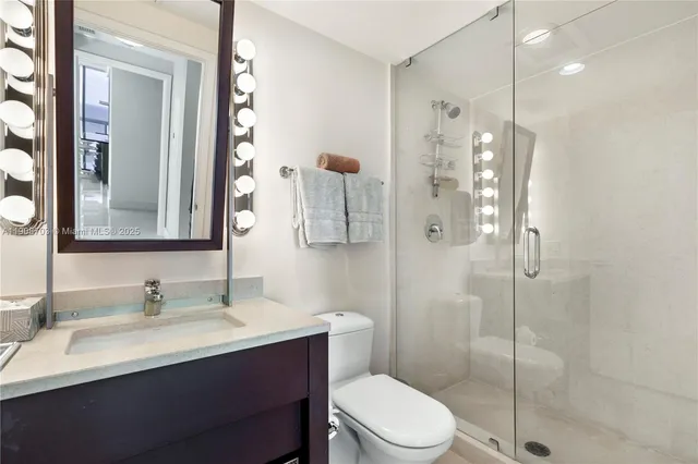 a bathroom with a sink vanity granite toilet and shower