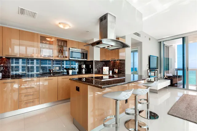 a kitchen with stainless steel appliances kitchen island granite countertop a stove and cabinets