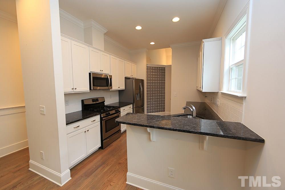 449 Rose Lane Raleigh, NC 27610 - Photo 3 of 14 a kitchen with granite countertop a sink a counter top space stainless steel appliances and cabinets