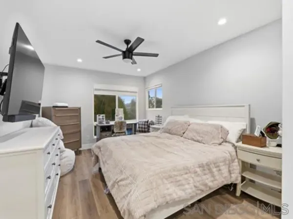 a bedroom with a bed a large window and flat screen tv