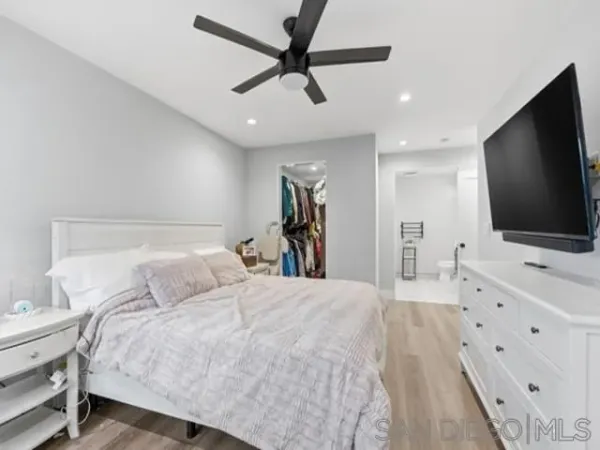 a bedroom with a bed and a flat tv screen on dresser