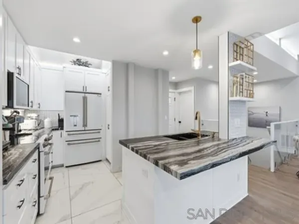 a kitchen with stainless steel appliances granite countertop a sink stove and refrigerator